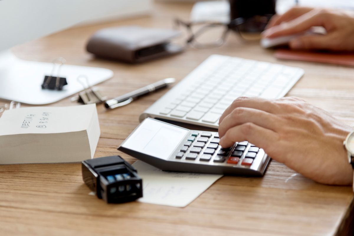Une main d'homme utilise une calculatrice