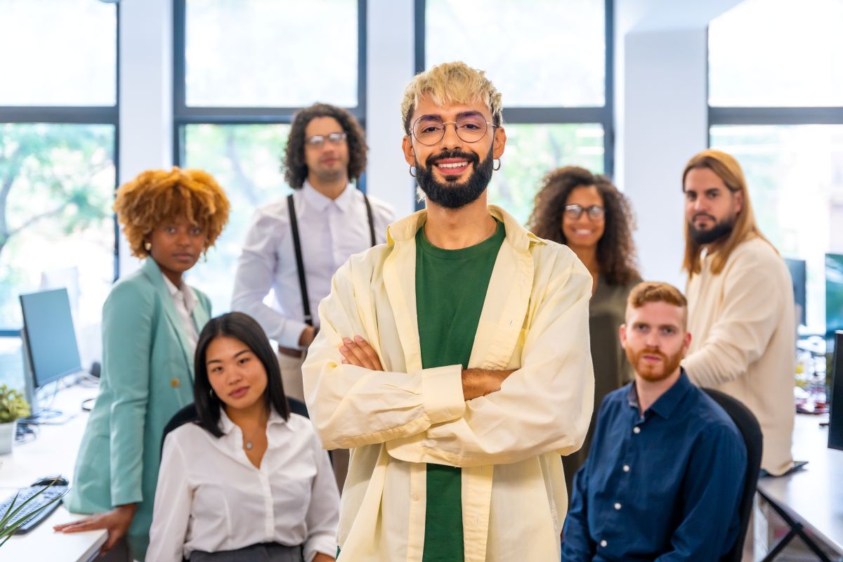 Jeune doctorant moderne souriant à la caméra à côté de ses collègues