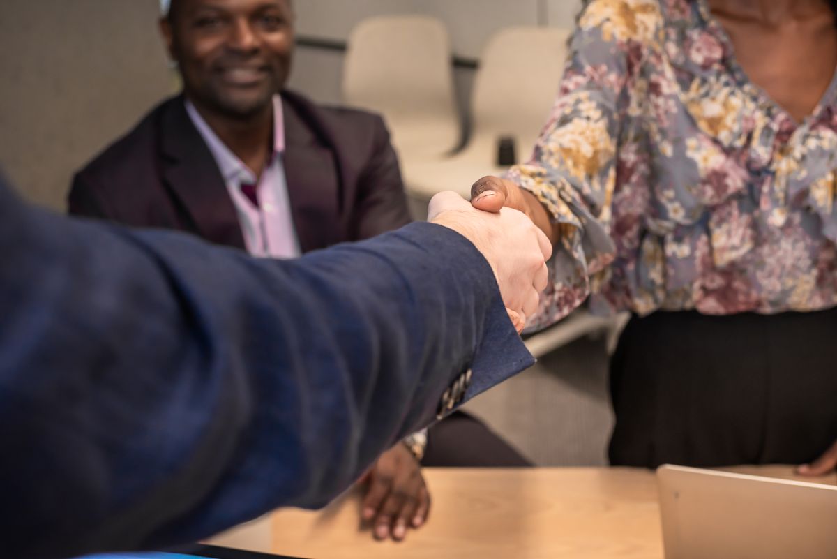 Une femme sert la main à un homme dans un bureau