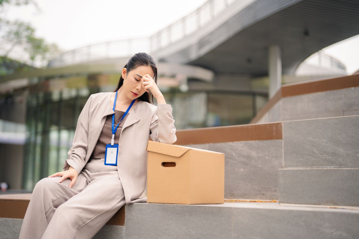 Une femme d'affaires déprimée est assise dans les escaliers à l'extérieur du bureau