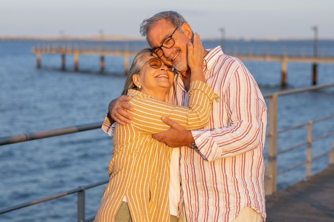 Un couple de retraité s'enlace sur la plage
