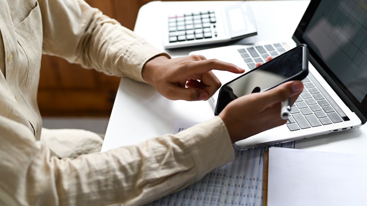 Un homme sur son smartphone calcule ses factures