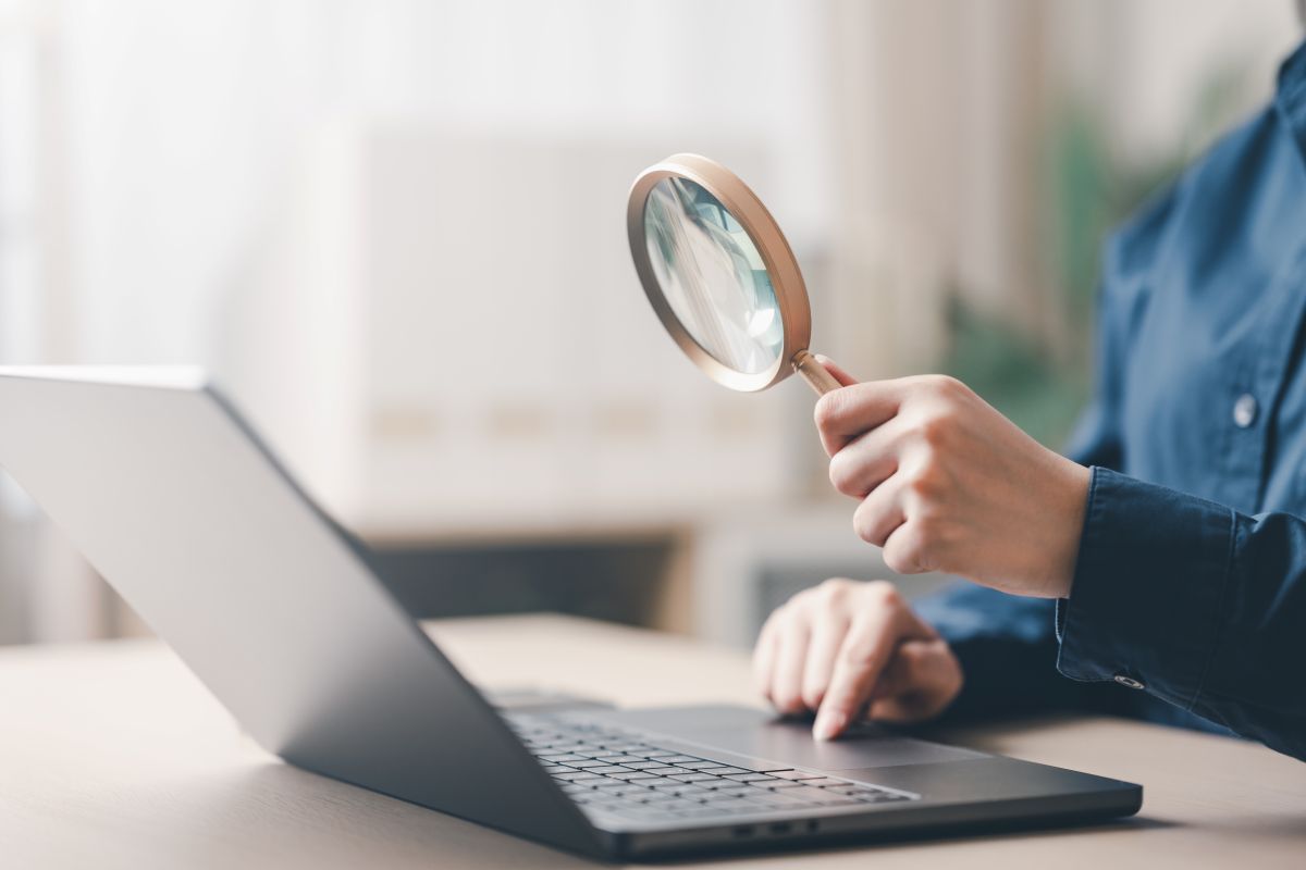 Un homme utilise une loupe pour faire des recherches